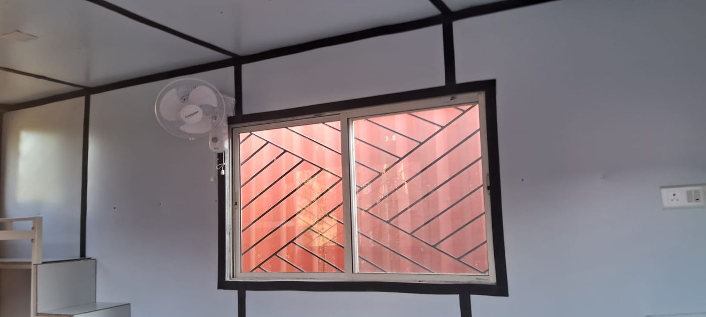 Insulated, wired room with wall fan and sliding window